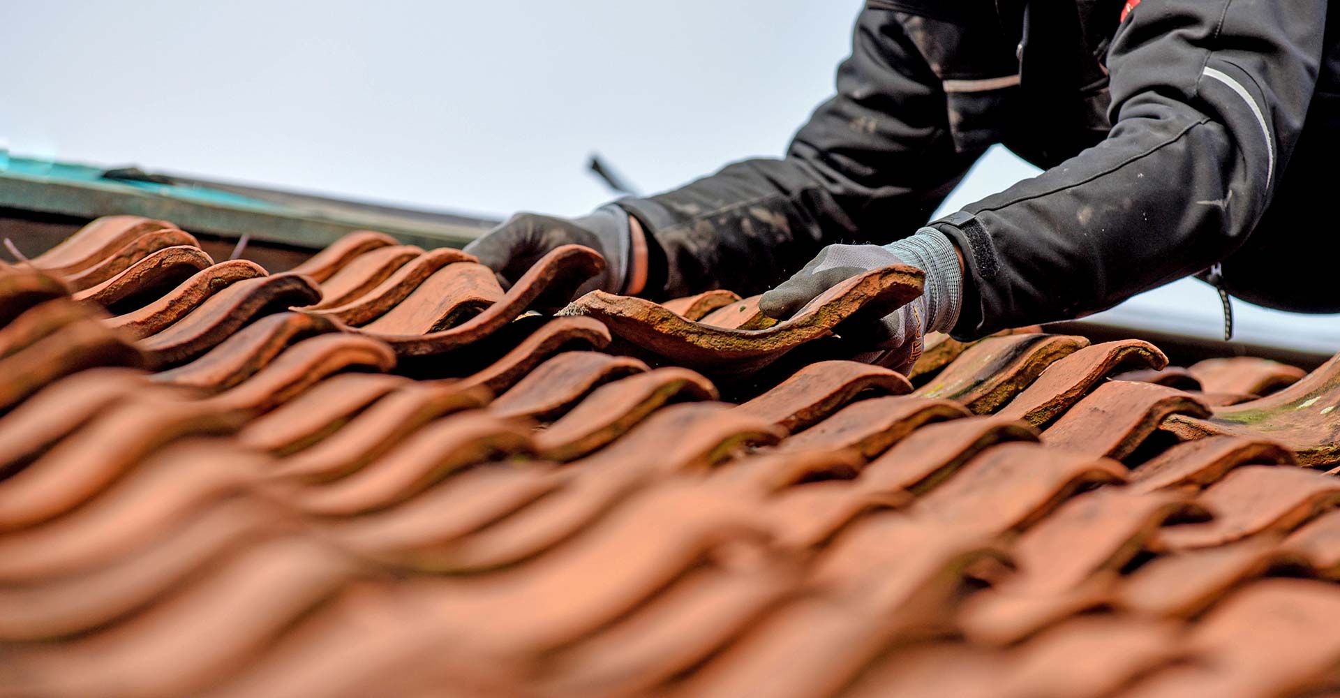 Roofer fixing clay roof tiles